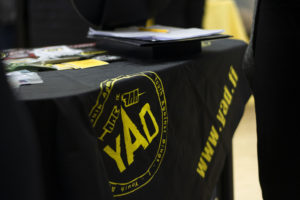 Kuva mustasta pöytäliinasta, jossa YAD:n logo.